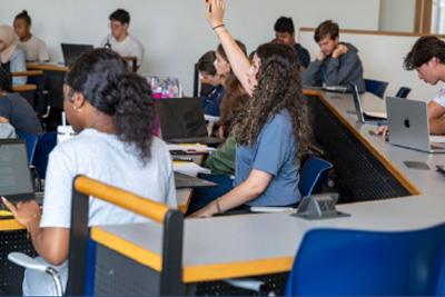 Student raising hand in classroom.